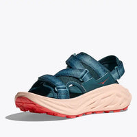 Blue sandal with a red sole on a white background