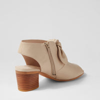 Beige ankle boot with wooden block heel on a light gray background