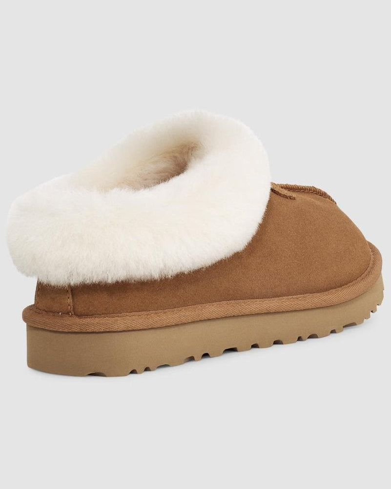 Brown slipper with white fur lining on a light gray background