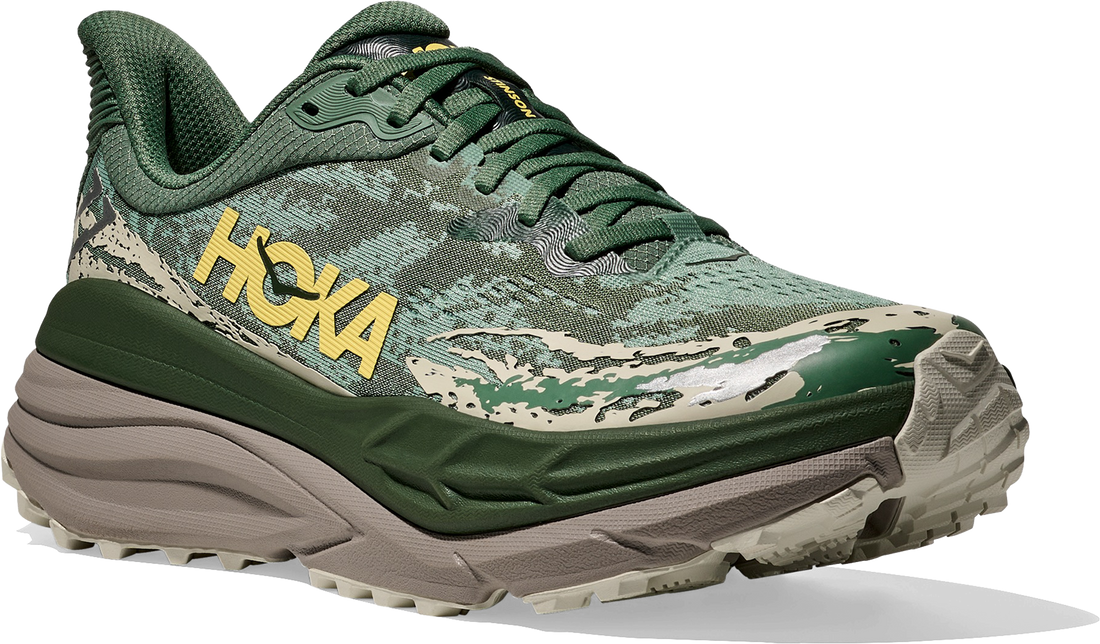 Green Hoka running shoe on a white background