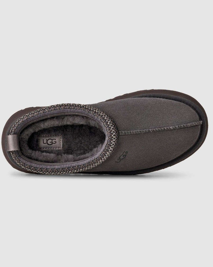 Dark gray UGG slipper on a light gray background
