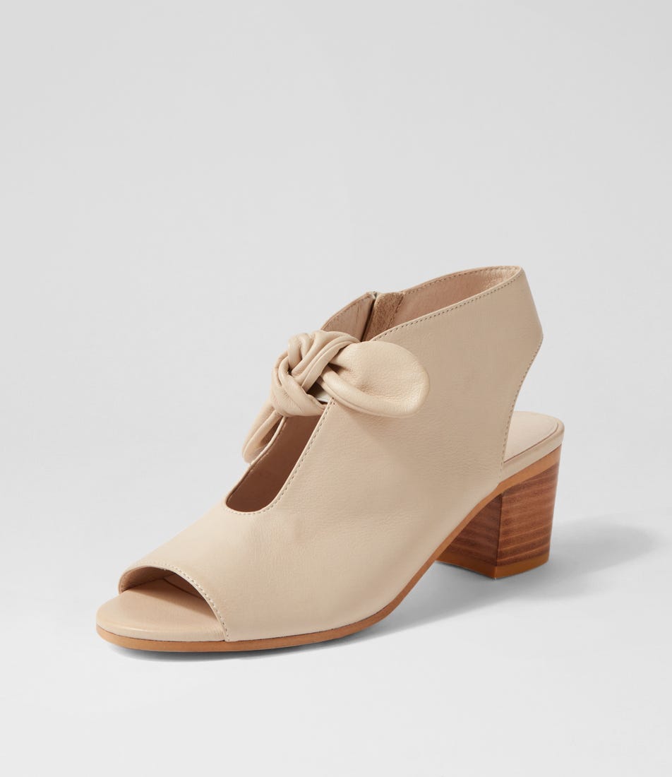 Beige open-toe shoe with wooden heel on a light gray background