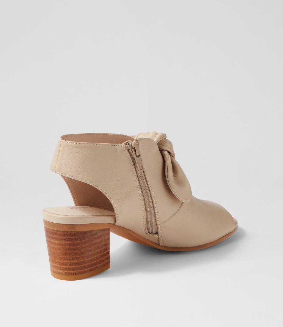 Beige ankle boot with wooden block heel on a light gray background