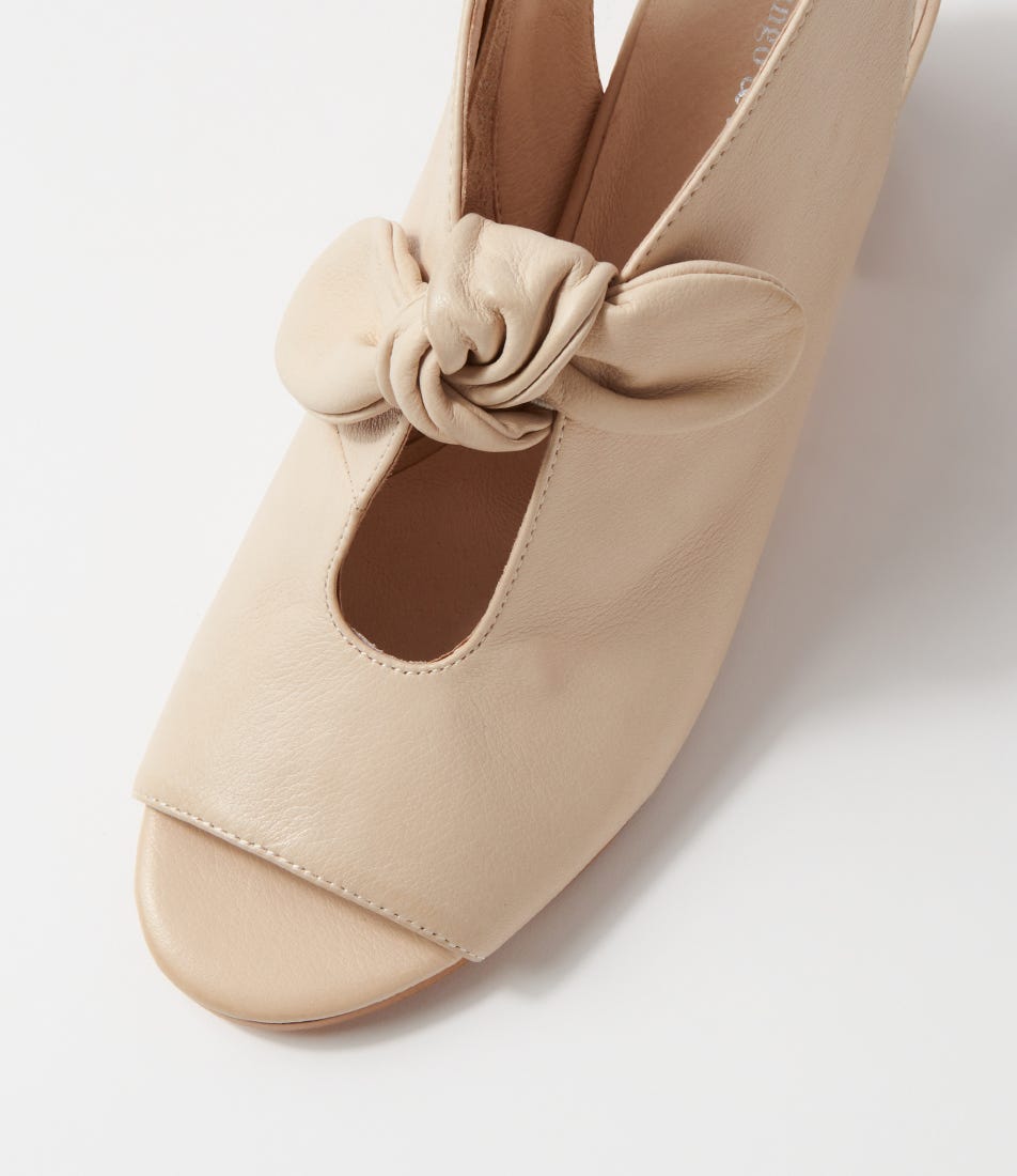 Beige shoe with a knot detail on a light gray background