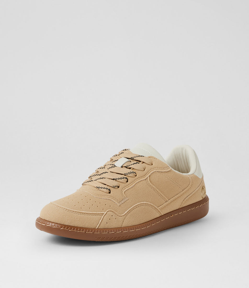 A low-top suede sneaker in beige with a brown gum sole, beige laces, and a cream collar, shown from a three-quarters angle on a light gray background.