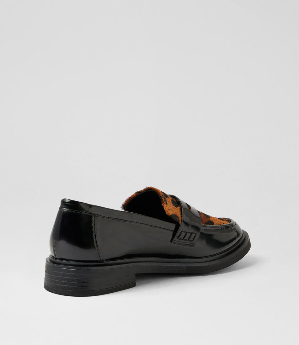 A black patent leather loafer with a brown and black patterned insole, shown from a side-rear angle on a light gray background.