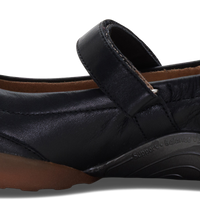 A black leather Mary Jane flat shoe with a hook-and-loop strap, shown in a side profile view against a white background.