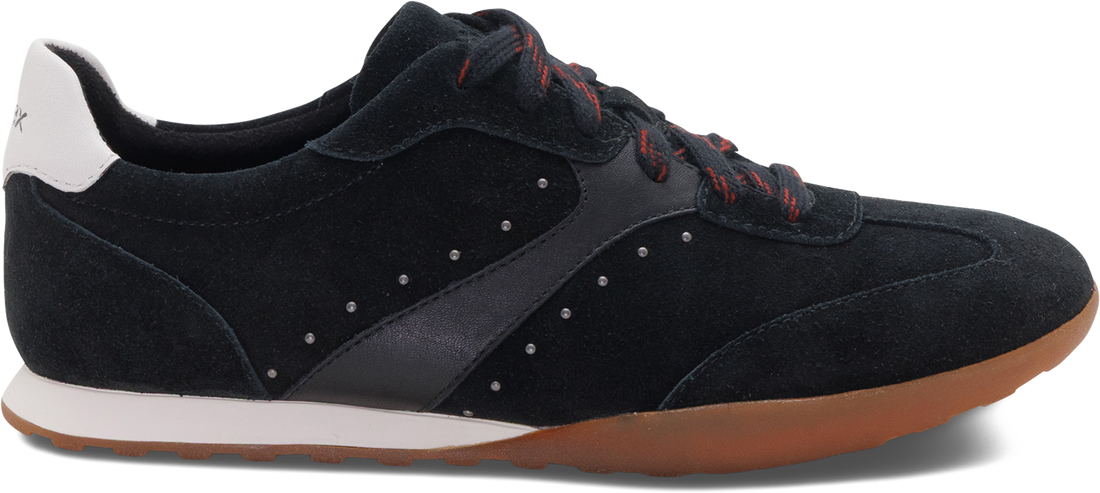 A black suede and synthetic fabric low-top sneaker with red laces, a white heel tab, and a brown gum sole, shown from a side profile on a white background.