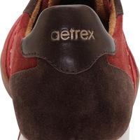 Close-up rear view of a brown and red suede sneaker with a white midsole and the 'aetrex' logo on the heel tab.
