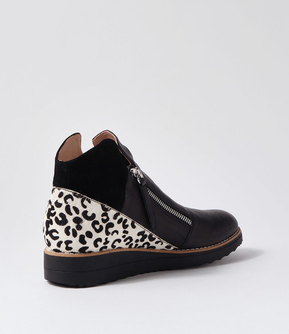 Black wedge shoe with leopard print pattern on a light gray background