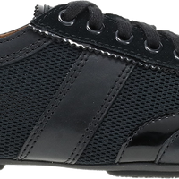 A black low-top sneaker with a mix of smooth leather and perforated mesh panels, featuring black laces and a black sole, shown from a side profile view on a white background.