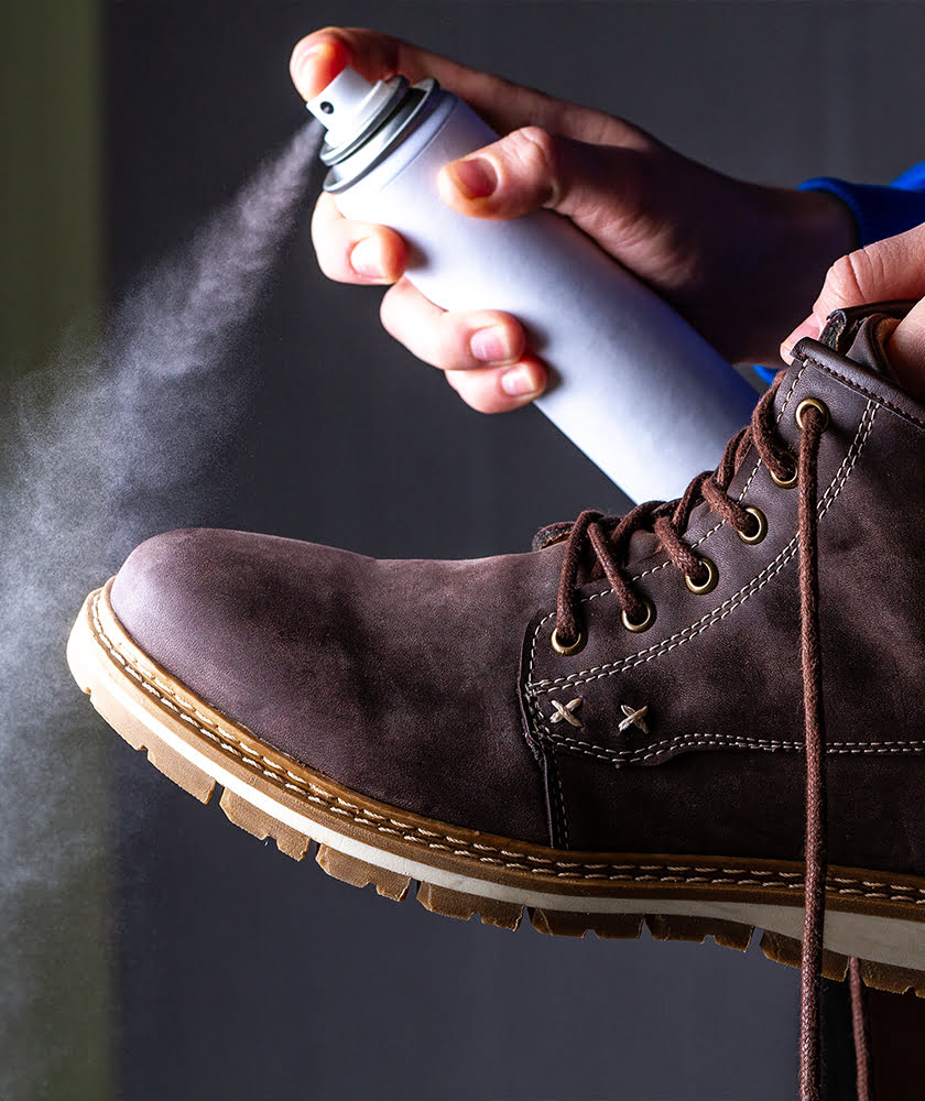 Spraying a pair of boots with a care product that will prolong the quality of these boots!