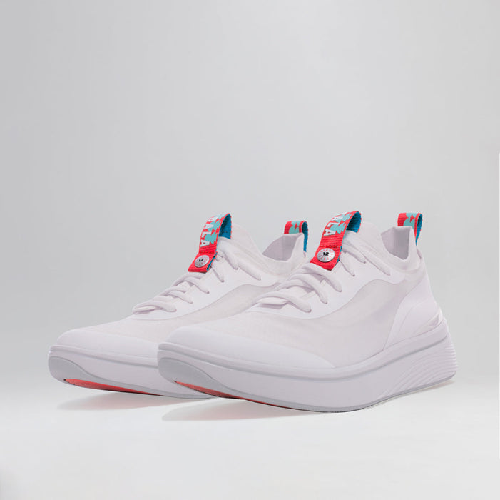 A pair of BALA Twelves in Flow White, which are bright white athletic-style sneakers for nurses and healthcare workers. They have white laces and bright red and sky blue details on the tongue and heel, and are photographed on the diagonal against a white background. A bright red sole is slightly visible beneath the toe.